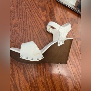 White wedge sandals with wooden heals.